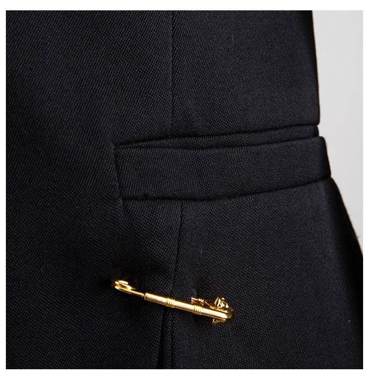 Black blazer with gold safety pin embellishments.